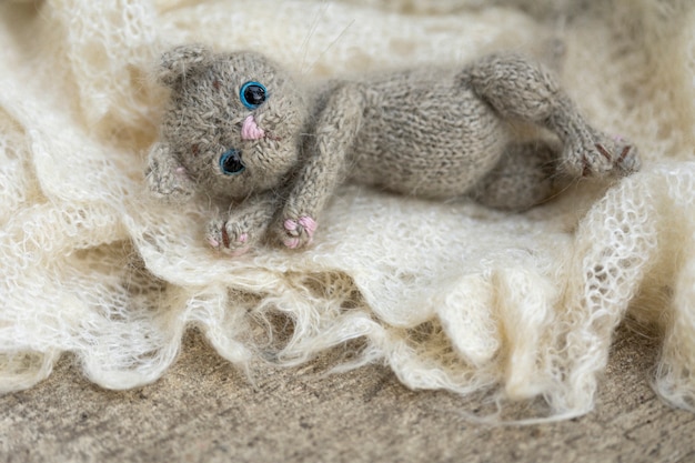 Gestricktes Spielzeugkätzchen, graues Kätzchen in Schals