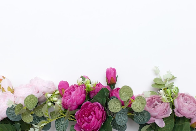 Gestyltes Stockfoto Dekorative Stillleben-Blumenkomposition Hochzeits- oder Geburtstagsstrauß aus rosa und weißen Pfingstrosenblüten und Eukalyptuszweigen Weißer Tischhintergrund Flache Lage von oben
