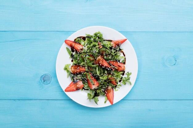Gesunde Bio-Diät-Salat mit Rucola, Erdbeeren und Sesam mit Balsamico-Glasur