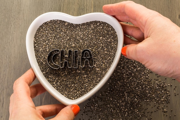 Gesunde Chia-Samen in einer Herzform-Schüssel-Nahaufnahme.