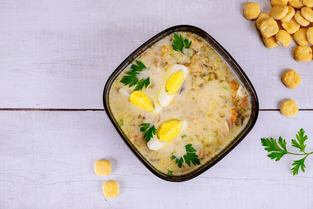 Gesunde cremige Gemüsesuppe mit Ei und Crackern