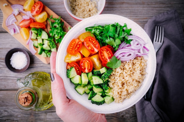 Gesunde Entgiftung Quinoa Tabouleh Salatschüssel mit frischen Gurken, Tomaten und roten Zwiebeln