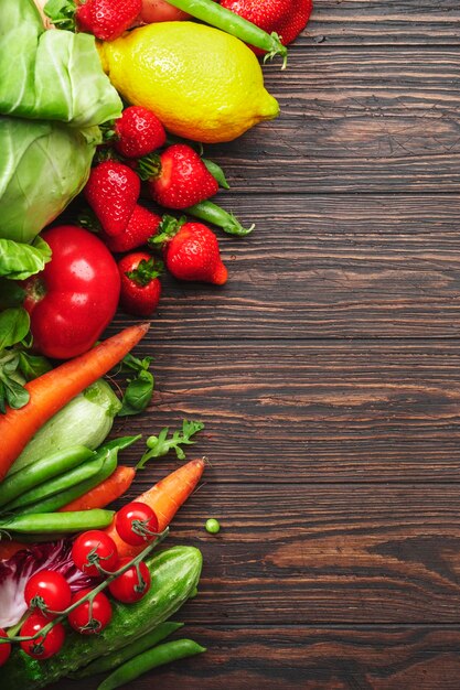 Gesunde Ernährung Auswahl an frischem Sommergemüse, Obst und Beeren aus biologischem Anbau auf Holztischhintergrund