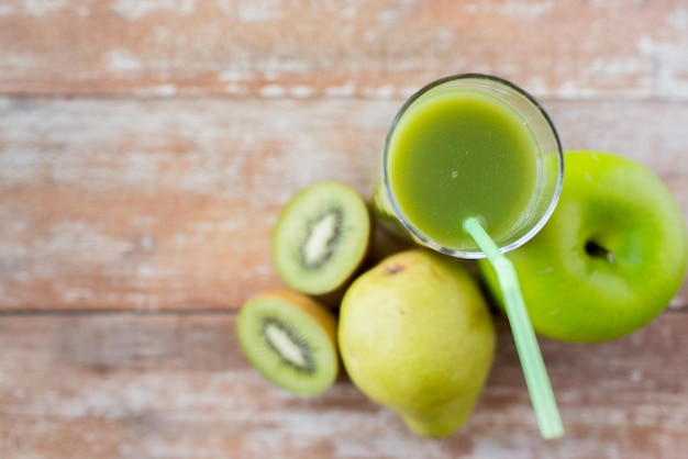 Gesunde Ernährung, Bio-Lebensmittel und Ernährungskonzept - Nahaufnahme von frischem grünem Saftglas und Früchten auf dem Tisch