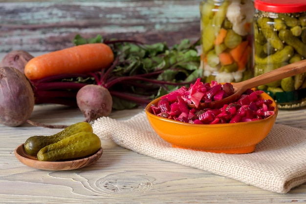 Gesunde Ernährung Der Rote-Bete-Salat Gekochtes und eingelegtes Gemüse in kleine Stücke geschnitten in einer Schüssel mit Olivenöl auf einem Holztisch in der Nähe