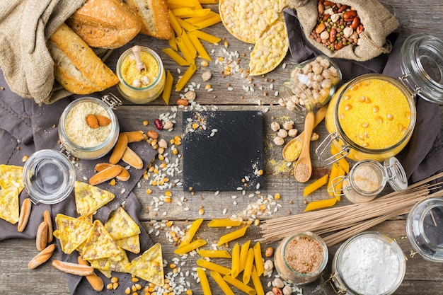 Gesunde Ernährung, Diät, ausgewogenes Lebensmittelkonzept. Auswahl an glutenfreien Lebensmitteln und Mehl, Mandeln, Mais, Reis auf einem Holztisch. Draufsicht flach legen Hintergrund