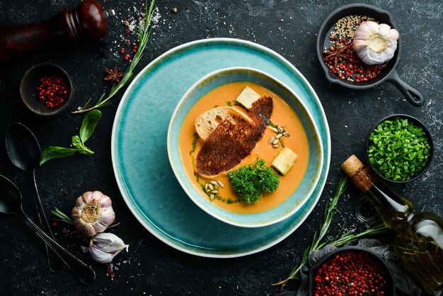 Gesunde Ernährung Erbsencremesuppe mit Toast auf einem Teller auf schwarzem Steinhintergrund Draufsicht Rustikaler Stil