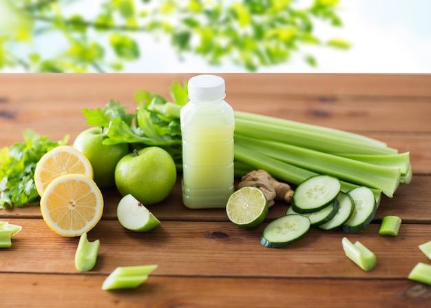 gesunde Ernährung, Ernährung, Diät und vegetarisches Konzept - Flasche mit grünem Saft, Obst und Gemüse auf Holztisch vor grünem Naturhintergrund