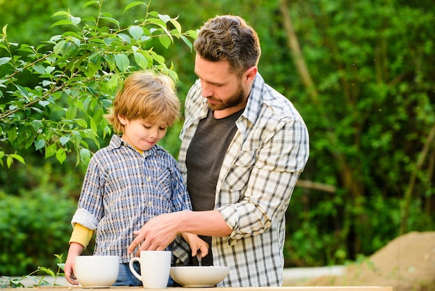 Foto gesunde ernährung familientag, der kleine jungen mit papa verbindet, sie lieben es, zusammen zu essen wochenendfrühstück bio- und naturkost vater und sohn essen im freien vegetarisches konzept