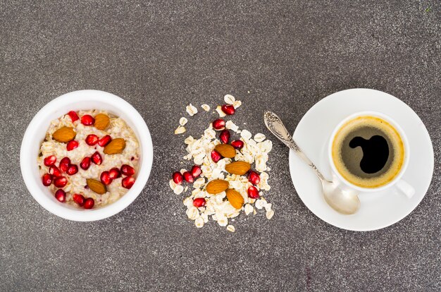 Gesunde Ernährung, Frühstück. Haferflocken mit Granatapfel und Nüssen, schwarzer Kaffee.