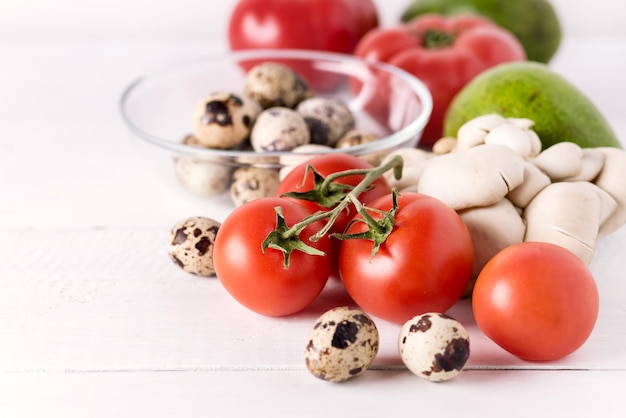 Gesunde Ernährung Lebensmittel auf weißem Hintergrund Gemüse Tomaten Paprika grüne Blätter Pilze Eier