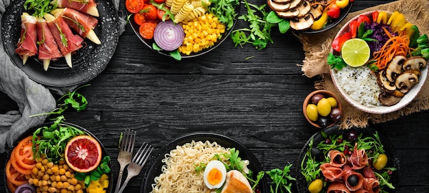 Gesunde Ernährung Sortiment der Buddha Bowl auf schwarzem Hintergrund Ansicht von oben Freier Platz für Ihren Text