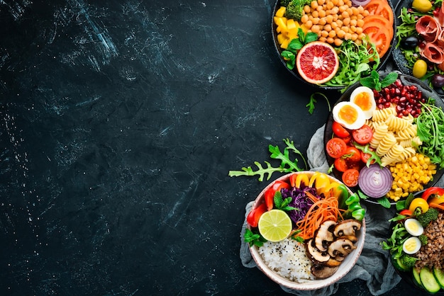 Gesunde Ernährung Sortiment der Buddha Bowl auf schwarzem Hintergrund Ansicht von oben Freier Platz für Ihren Text