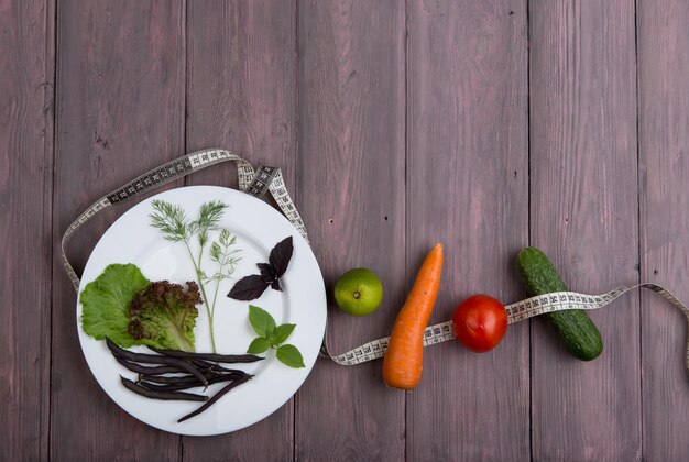 Gesunde Ernährung und vegetarisches Ernährungskonzept Maßband weißer Teller mit Gemüse