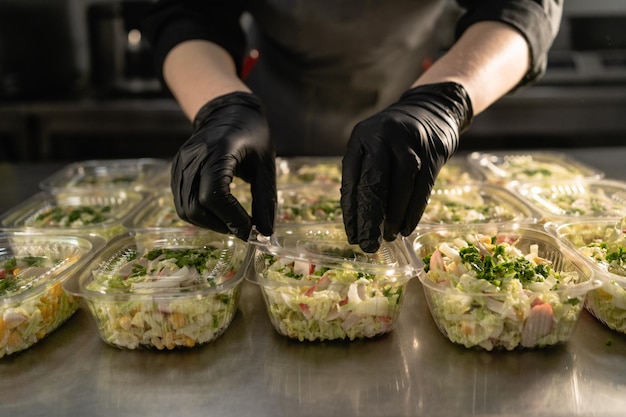 Foto gesunde essenslieferung bio-gesunder salat in einer einwegschüssel sauberes essen konzept gesundes essen koch deckt lunchboxen ab