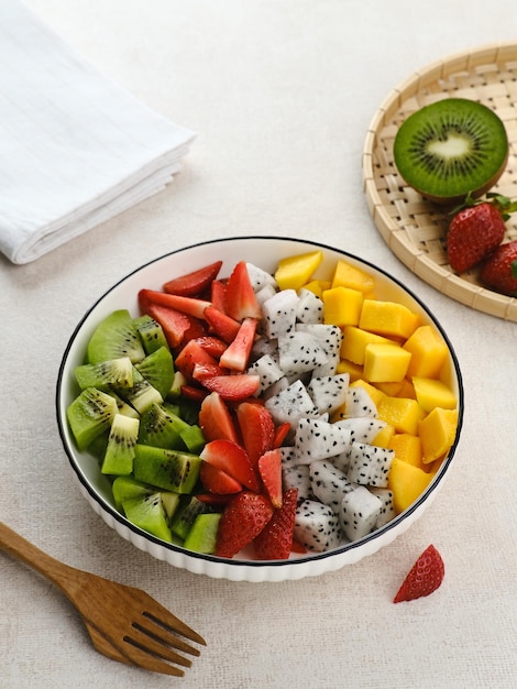 Gesunde frische Obstsalatschüssel Drachenfrucht Kiwi Mango Erdbeere auf dem Tisch Ausgewählter Fokus