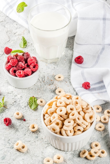 Gesunde Frühstückszutaten. Frühstücksflocken-Maisringe, Milch- oder Joghurtglas