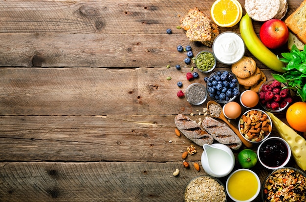 Gesunde Frühstückszutaten, Lebensmittelrahmen. Müsli, Eier, Nüsse, Früchte, Beeren, Toast, Milch, Joghurt