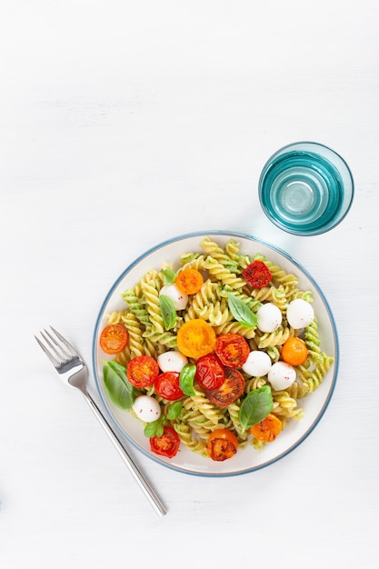 Gesunde Fusilli-Nudeln mit Pesto-Sauce, gerösteten Tomaten, Mozzarella