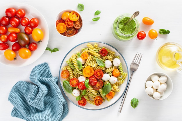 Gesunde Fusilli-Nudeln mit Pesto-Sauce, gerösteten Tomaten, Mozzarella