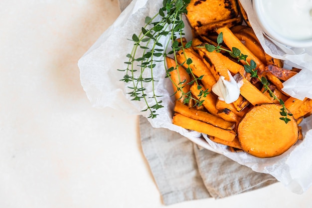 Gesunde hausgemachte gebackene Süßkartoffelecken mit Sahne-Dip-Sauce und Kräutern Gesunder Snack