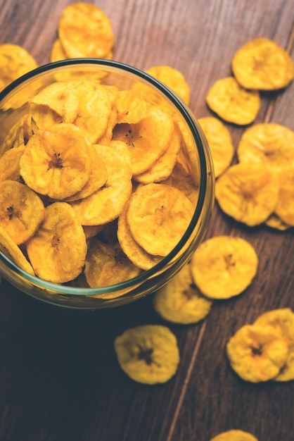 Gesunde hausgemachte Kela- oder Bananenchips oder Waffeln, serviert über stimmungsvoller Oberfläche, selektiver Fokus