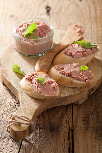 Gesunde Hühnerleberpastete mit Salbei im Glas und auf Brot