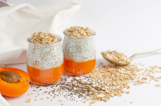 Gesunde Joghurt-Chia-Puddings mit frischen rohen Aprikosen- und Haferflocken.