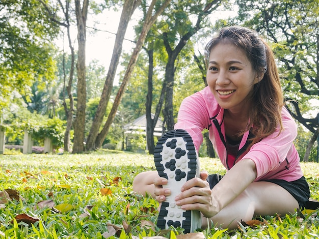 Gesunde junge asiatische Frau, die am Park trainiert