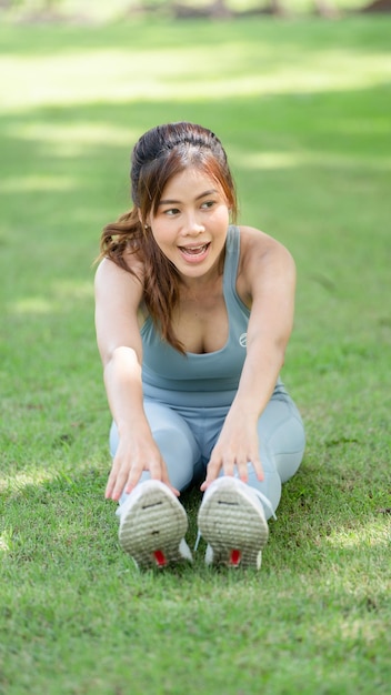 Gesunde junge weibliche Trainingsübung vor dem Laufen oder Fitnesstraining im Stadtpark