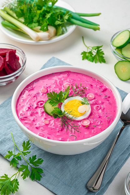 Gesunde kalte Rote-Bete-Suppe mit Ei auf hellgrauem Hintergrund. Vertikale Ansicht.