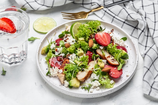 Gesunde Mahlzeit Erdbeersalat mit Hühnerfleisch Avocado, Feta-Käse, Salat und Nüssen Balsamico-Essig. Detox und gesundes Superfoods-Konzept.