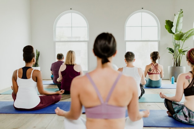 Gesunde Menschen, die im Yoga-Kurs eine Sukhasana-Yoga-Pose machen