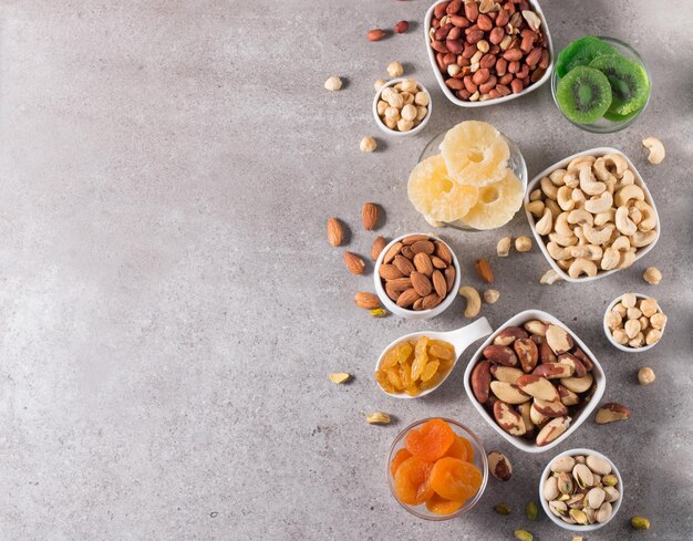 Foto gesunde mischung aus nüssen und getrockneten früchten auf hölzernem hintergrund mandeln, haselnüsse, cashews und erdnüsse