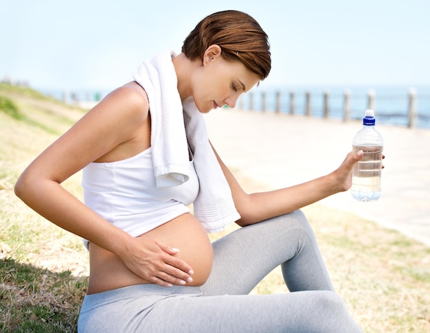 Gesunde Mutter, gesundes Baby Eine schwangere Frau, die sich von ihrem Training im Freien erholt