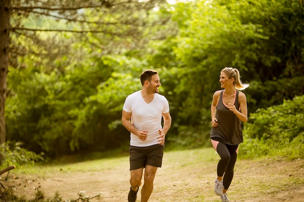 Gesunde passform und sportliche paare, die in natur laufen