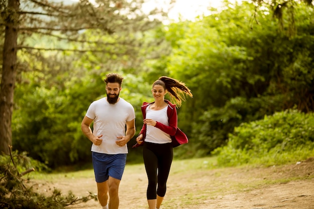 Gesunde Passform und sportliche Paare, die in Natur laufen