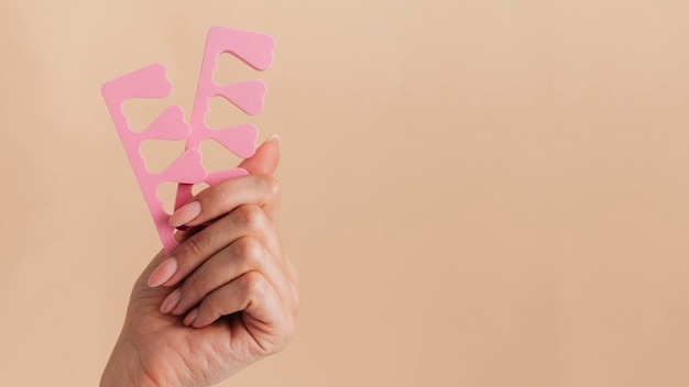 Gesunde Pflege der Maniküre, die rosa Nagelzubehör hält