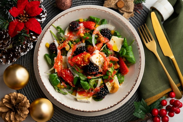 Gesunde rote Beeren- und Brie-Salat Top-View-Tisch mit Weihnachtsdekorationen