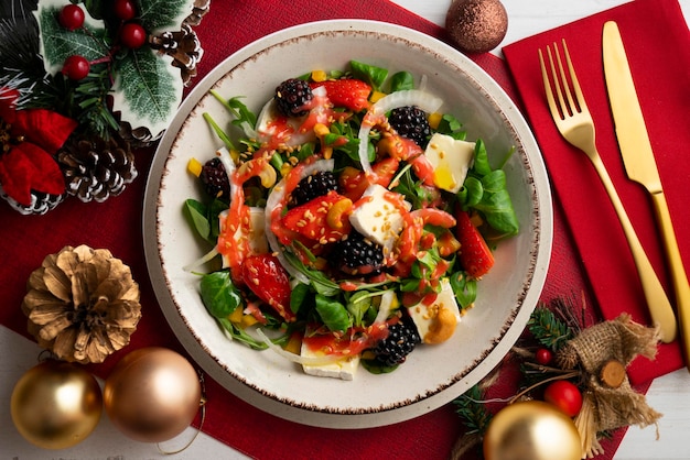 Gesunde rote Beeren- und Brie-Salat Top-View-Tisch mit Weihnachtsdekorationen