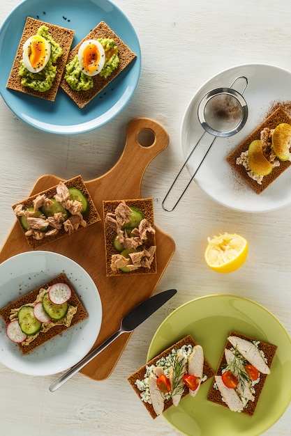 Gesunde Sandwiches mit verschiedenen Füllungen auf knusprigem Roggenbrot.