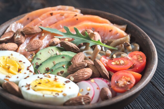 Gesunde Schüssel mit Lachs, Avocado, Ei und Gemüse