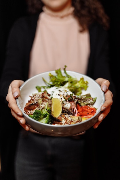 Gesunde Schüssel - Quinoa-Salat mit Thunfisch, Brokkoli, Avocado auf rustikalem Holztisch. Ansicht von oben.