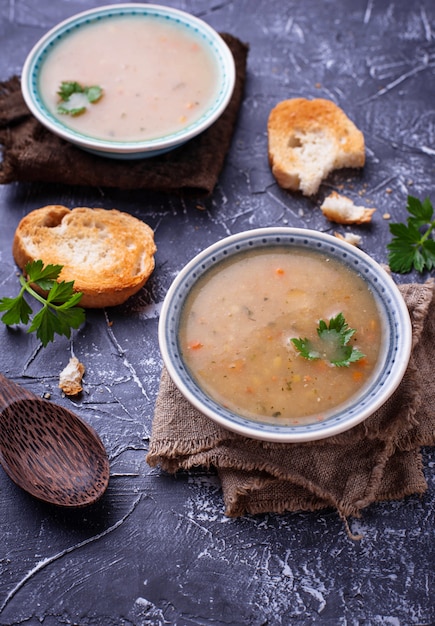 Gesunde Suppe der vegetarischen Erbsen auf konkretem Hintergrund