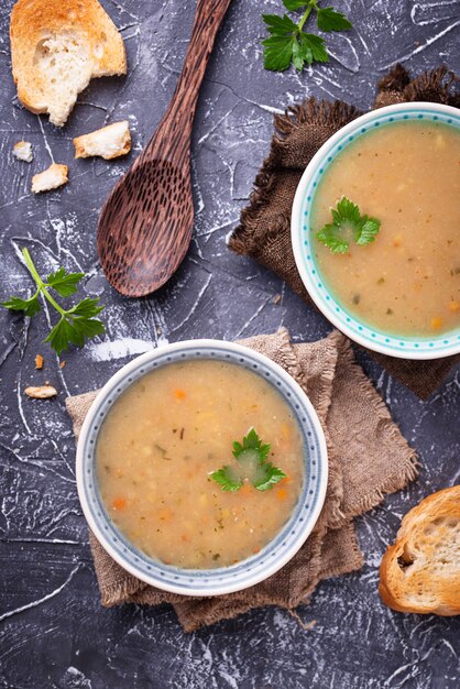 Gesunde Suppe der vegetarischen Erbsen auf konkretem Hintergrund