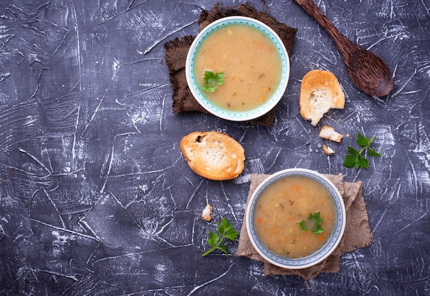 Gesunde Suppe der vegetarischen Erbsen auf konkretem Hintergrund