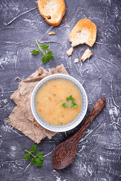 Gesunde Suppe der vegetarischen Erbsen auf konkretem Hintergrund