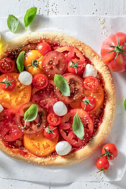 Gesunde und vegetarische Pizza Margherita mit verschiedenen Tomaten und Mozzarella