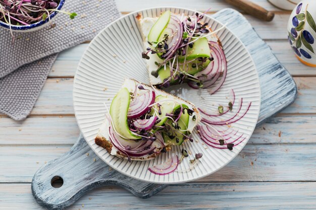 Gesunde vegetarische Bruschetta mit Brot, Mikrogemüse, Käse, Gurken und roten Zwiebeln