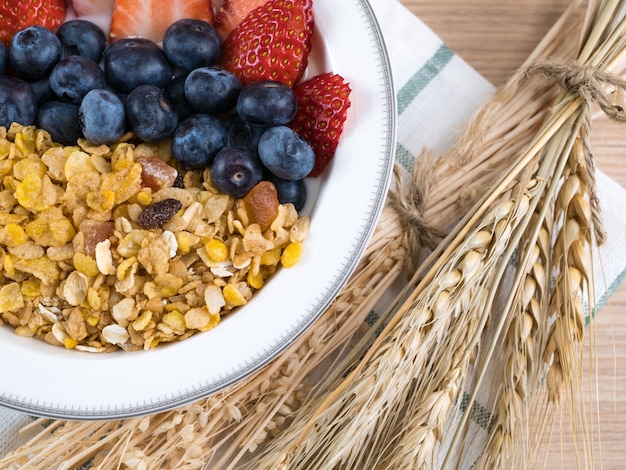 Gesunde Vollkornmehlgetreideflocken mit Erdbeere, Blaubeerbeeren mit Milch.